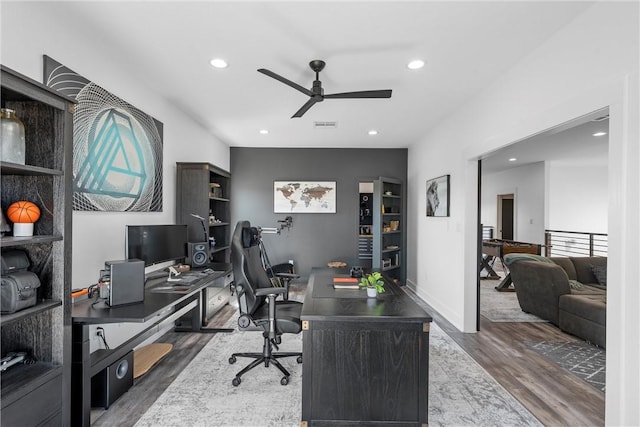 home office with dark wood-type flooring and ceiling fan