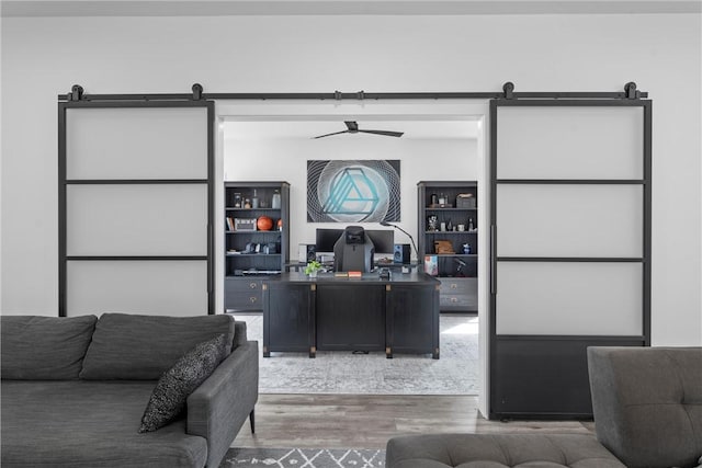 office with wood-type flooring and a barn door