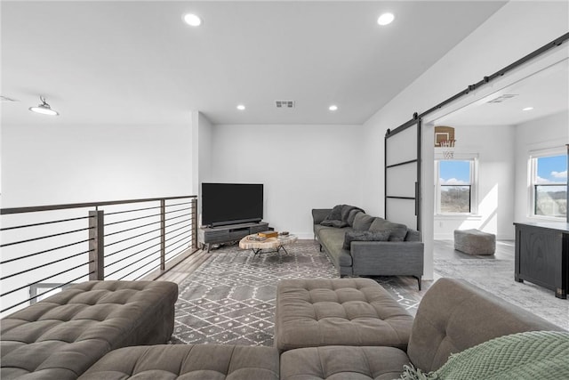 living room with wood-type flooring and a barn door