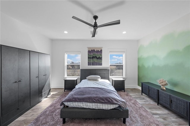 bedroom featuring multiple windows, ceiling fan, and light hardwood / wood-style floors