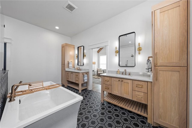 bathroom featuring a tub to relax in, vanity, and tile patterned floors