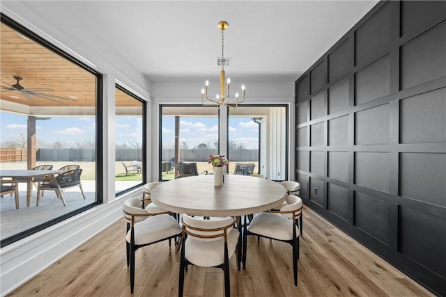 dining space featuring light hardwood / wood-style floors and a chandelier