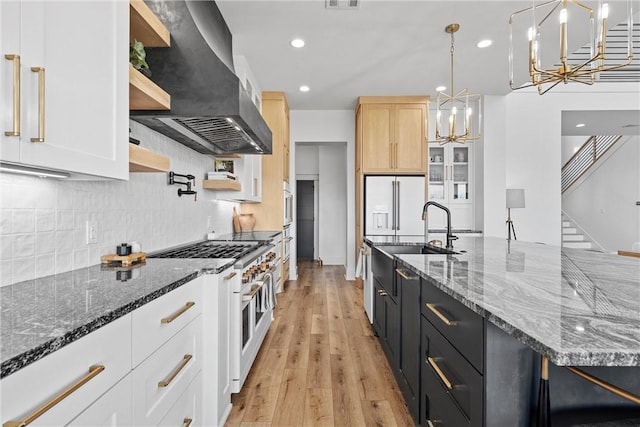 kitchen with high quality appliances, island exhaust hood, hanging light fixtures, and white cabinets