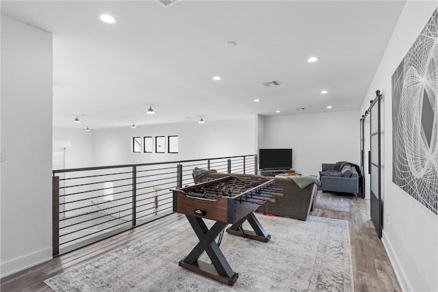 game room featuring hardwood / wood-style floors and a barn door