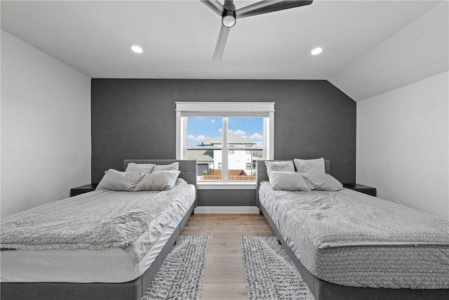 bedroom with ceiling fan, vaulted ceiling, and light hardwood / wood-style flooring