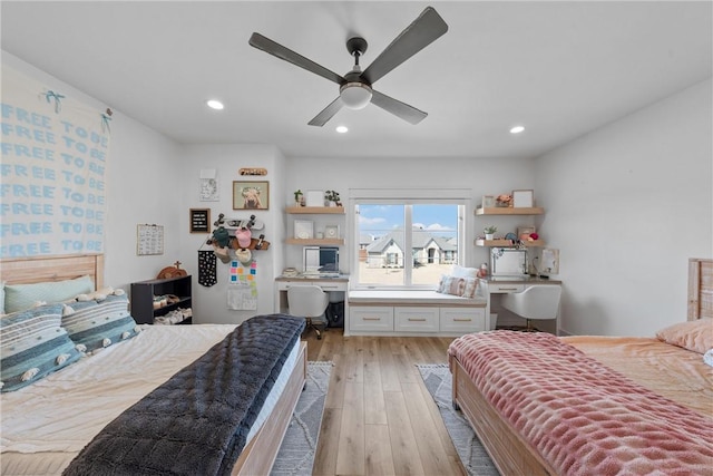 bedroom with light hardwood / wood-style flooring, built in desk, and ceiling fan