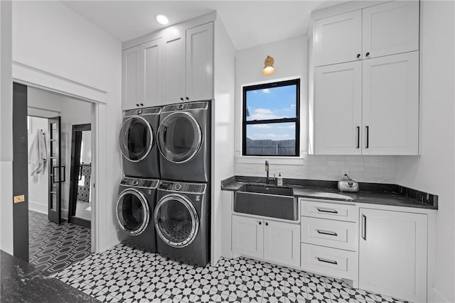 washroom featuring sink, cabinets, washing machine and clothes dryer, and stacked washing maching and dryer