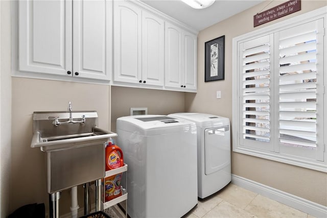 laundry area featuring washer and dryer, light tile patterned floors, and cabinets