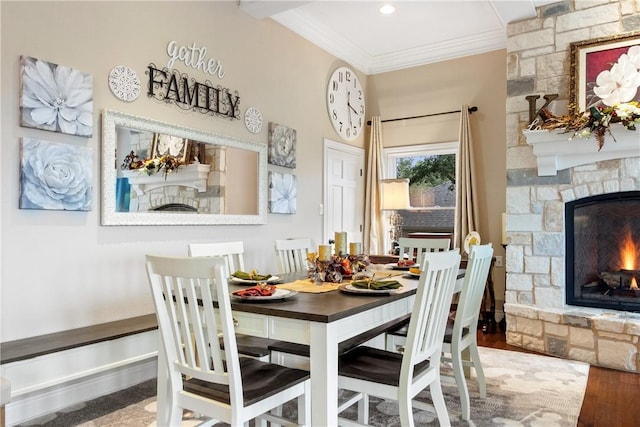 dining area featuring a fireplace, hardwood / wood-style floors, and ornamental molding