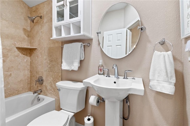 bathroom with tiled shower / bath combo and toilet