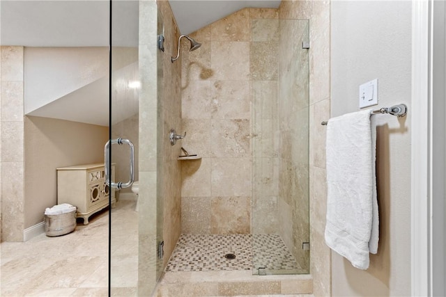 bathroom featuring toilet and a shower with door