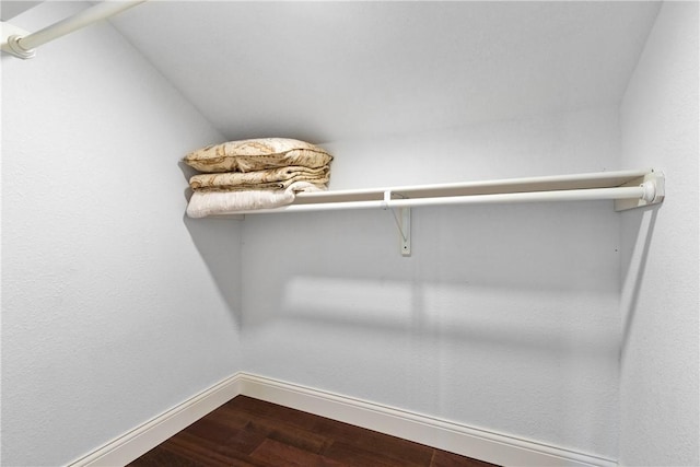 walk in closet featuring wood-type flooring and vaulted ceiling