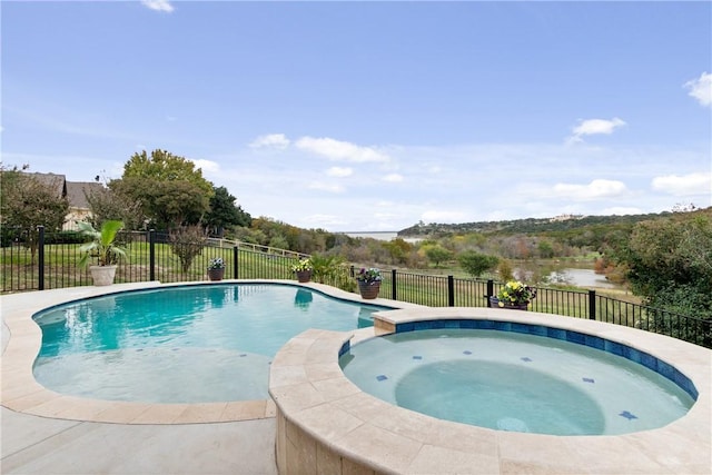 view of swimming pool with a water view and an in ground hot tub