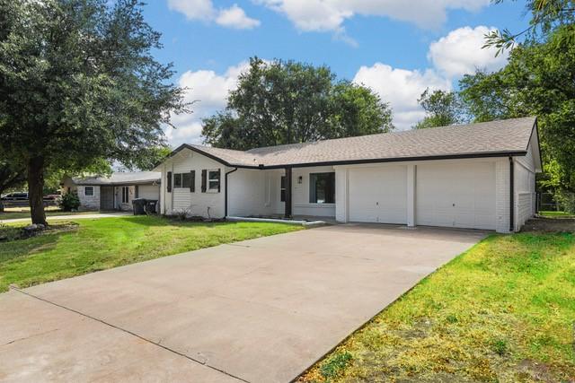 single story home featuring a garage and a front yard