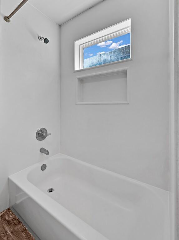 bathroom featuring shower / tub combination and wood-type flooring