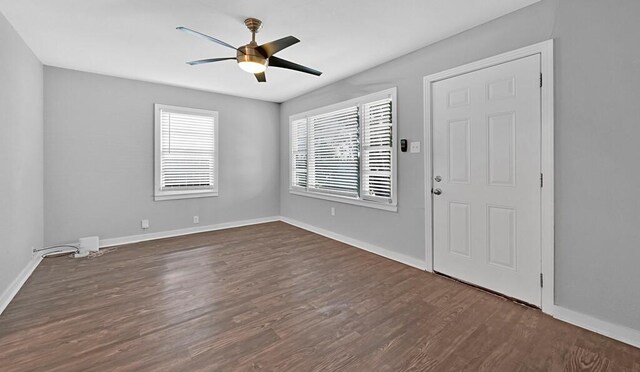 unfurnished room with ceiling fan and dark wood-type flooring