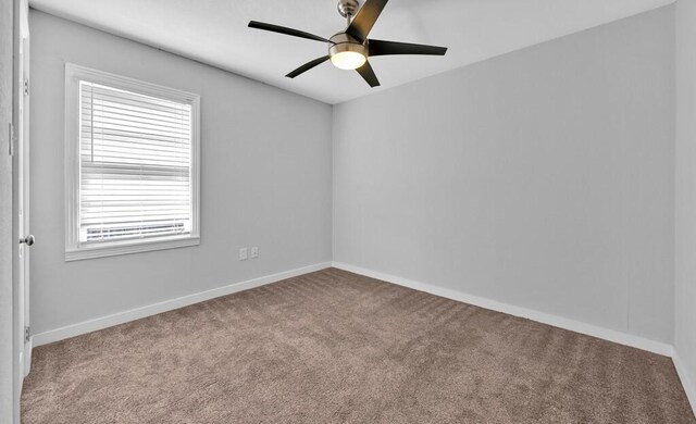 carpeted spare room with ceiling fan