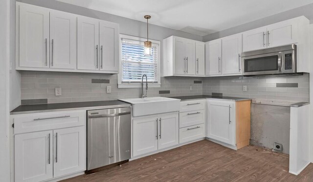 kitchen with sink, white cabinets, dark wood-type flooring, and appliances with stainless steel finishes