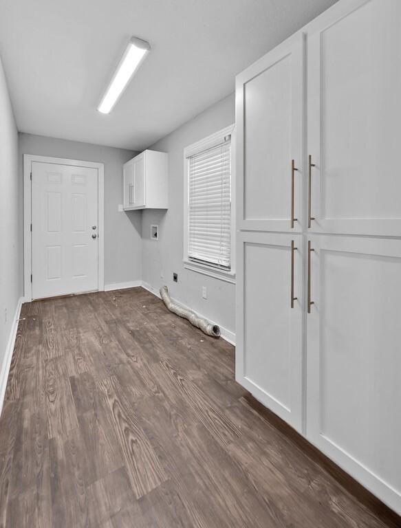 clothes washing area featuring cabinets, dark hardwood / wood-style floors, hookup for a gas dryer, and electric dryer hookup