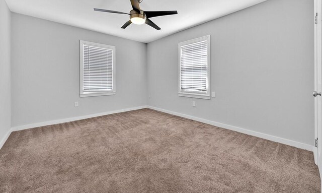 carpeted spare room featuring ceiling fan