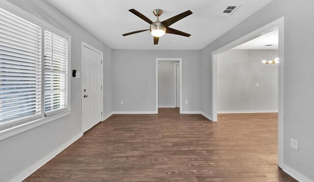 unfurnished room with dark hardwood / wood-style flooring and ceiling fan with notable chandelier