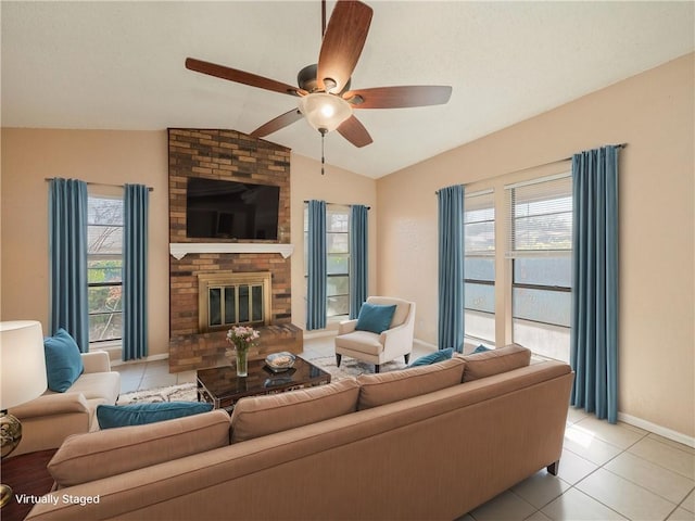 living room with light tile patterned floors, a healthy amount of sunlight, a brick fireplace, and lofted ceiling