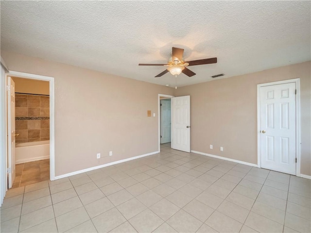 unfurnished bedroom featuring baseboards, visible vents, light tile patterned flooring, ceiling fan, and a textured ceiling