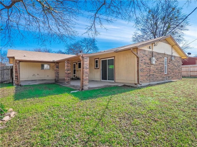 back of property with a patio, fence, a lawn, and brick siding