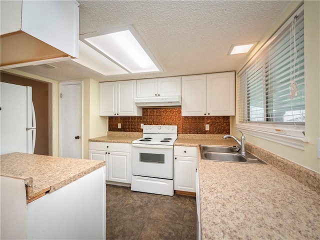 kitchen with white appliances, white cabinets, under cabinet range hood, and a sink