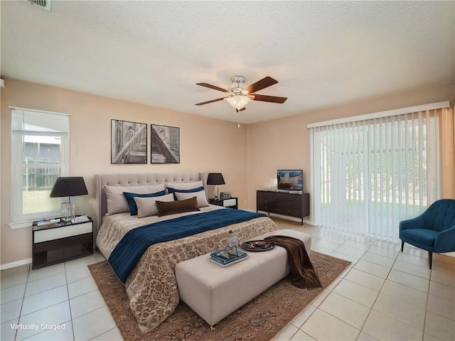 bedroom with baseboards, light tile patterned floors, a textured ceiling, a ceiling fan, and access to outside