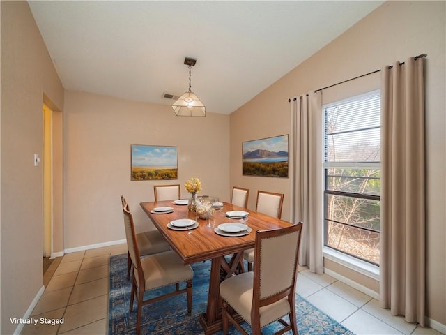 dining space with lofted ceiling, light tile patterned flooring, baseboards, and visible vents