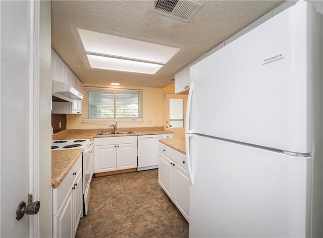 kitchen featuring white appliances, visible vents, a sink, white cabinets, and under cabinet range hood