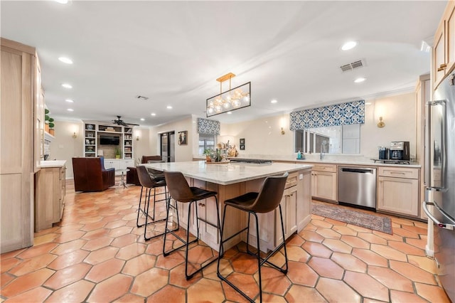 kitchen with a kitchen island, appliances with stainless steel finishes, a breakfast bar, pendant lighting, and light stone counters