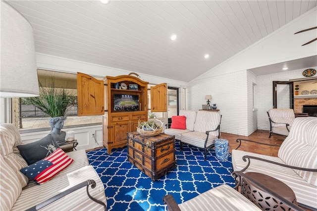 living room featuring vaulted ceiling, ornamental molding, wooden ceiling, and brick wall