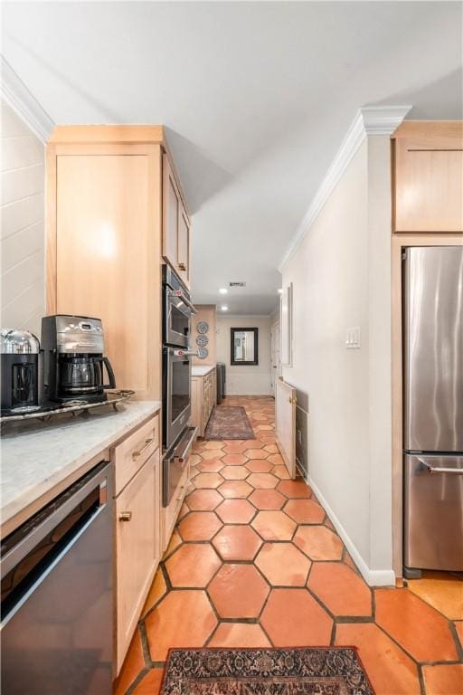 kitchen featuring ornamental molding, appliances with stainless steel finishes, and light brown cabinetry