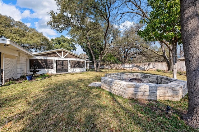 view of yard featuring a sunroom and a fire pit