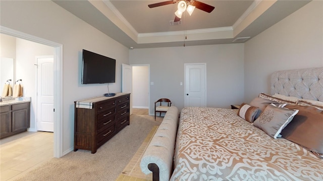 carpeted bedroom featuring ceiling fan, ornamental molding, connected bathroom, and a tray ceiling