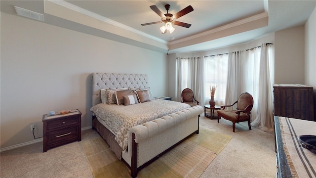 bedroom with ornamental molding, a tray ceiling, ceiling fan, and light colored carpet