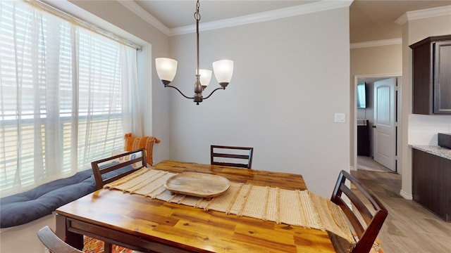 dining space with an inviting chandelier, ornamental molding, and light hardwood / wood-style flooring