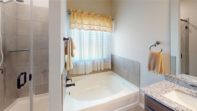 bathroom featuring vanity and shower with separate bathtub