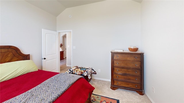 bedroom featuring light carpet and lofted ceiling