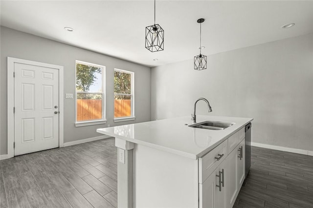 kitchen featuring sink, dark hardwood / wood-style flooring, an island with sink, decorative light fixtures, and white cabinets