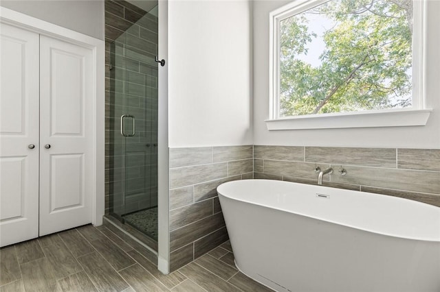 bathroom with a wealth of natural light and shower with separate bathtub