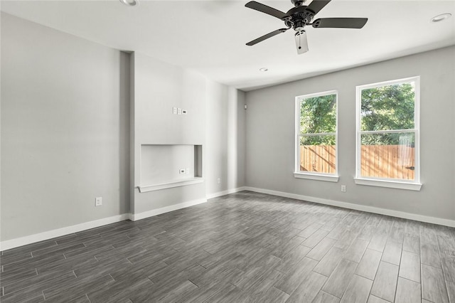 unfurnished room with ceiling fan and dark wood-type flooring