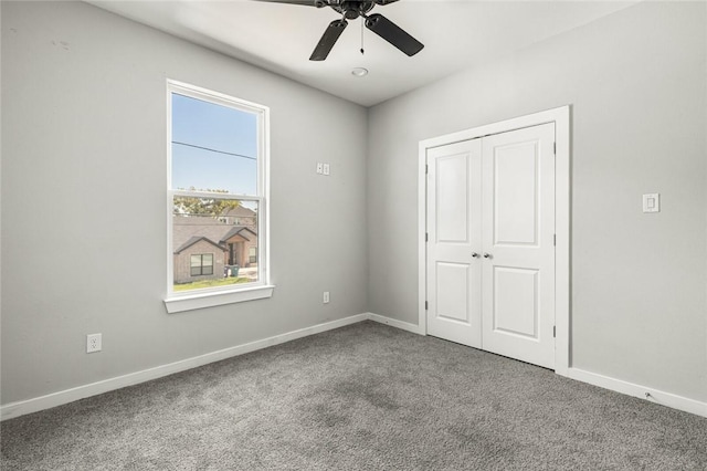 unfurnished bedroom with carpet, a closet, and ceiling fan