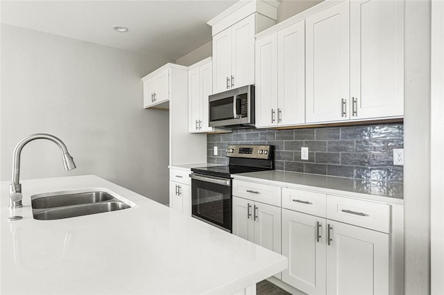 kitchen featuring white cabinets, sink, stainless steel appliances, and tasteful backsplash