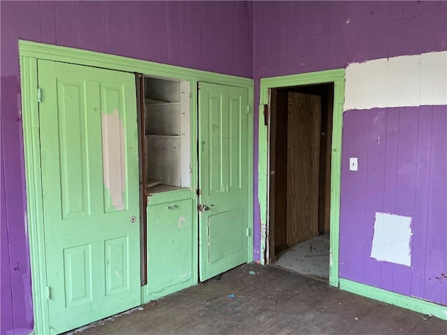 unfurnished bedroom featuring wood walls and a closet