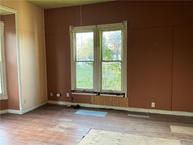 unfurnished room with hardwood / wood-style flooring