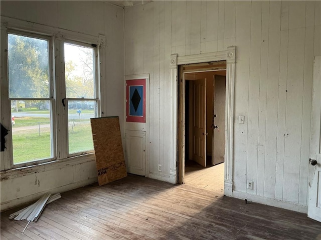 spare room featuring wood walls and hardwood / wood-style flooring