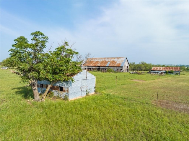 view of yard with a rural view and an outdoor structure